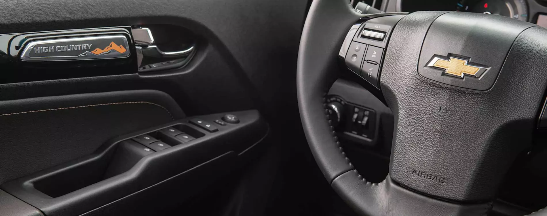 Fotografia feita no interior do veículo, mostrando alguns detalhes como os botões no volante e na porta do motorista