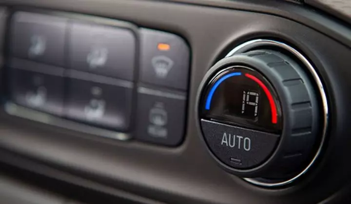 Fotografia feita no interior do veículo do botão de ajuste do ar-condicionado