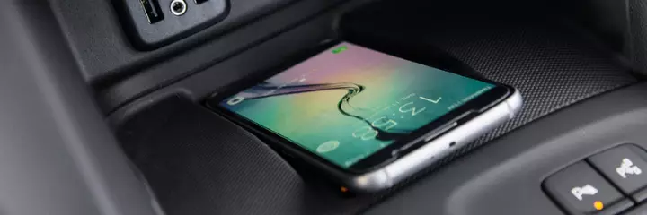 Fotografia feita no interior do veículo de um smartphone utilizando o carregador wireless charger